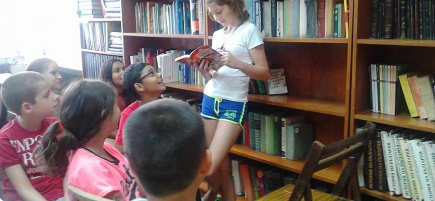 Доброволката Веселина Пепеланова занимава малчуганите с четене в Библиотеката